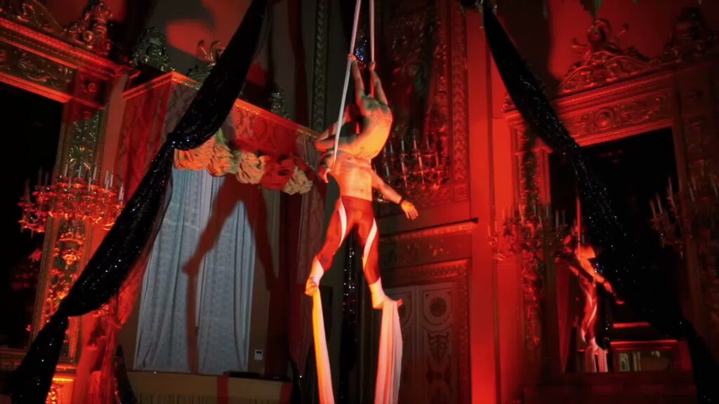Show per hotel di lusso: perché i format replicabili fidelizzano gli ospiti 2 Acrobati su tessuti aerei durante uno show per hotel di lusso — Utopia Show Art