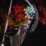 Violinista sospesa su una mezzaluna in un giardino notturno, spettacolo per matrimonio in villa — Utopia Show Art